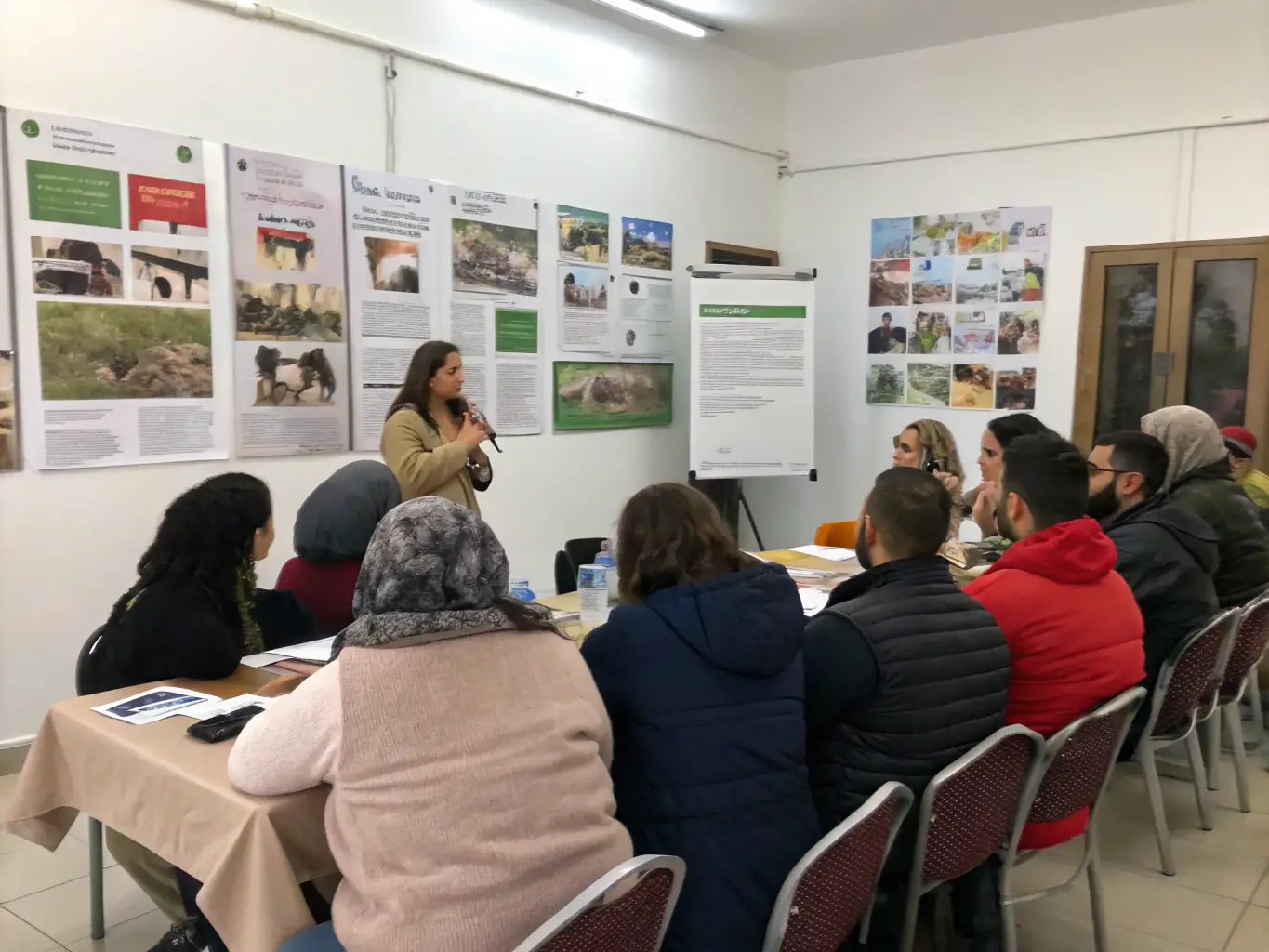 A picture of a group of people attending an educational workshop on wildlife conservation, with a presenter explaining key concepts.