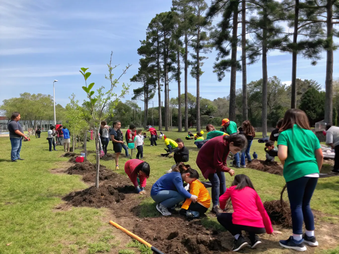 A community event organized by ASSOCIATION DU VAL DES TREZ, showing families and individuals participating in a nature conservation activity.